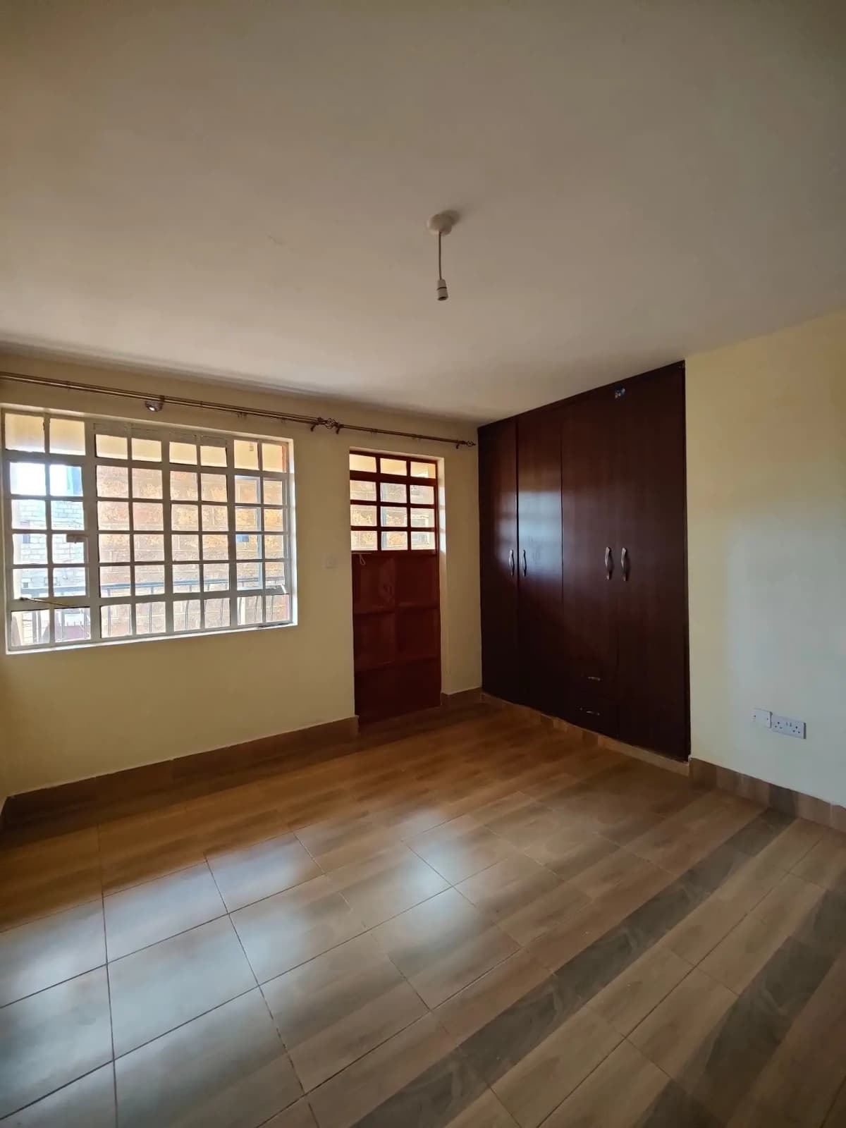 Spacious bedroom with wooden flooring and built-in wardrobe