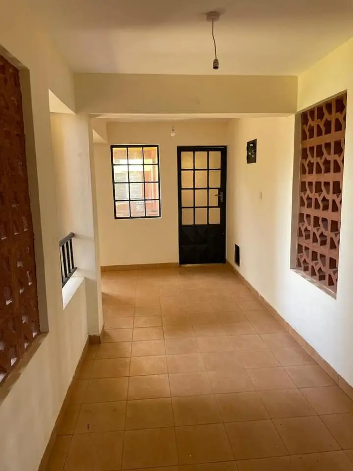 Bright corridor with tiled flooring and entrance doors