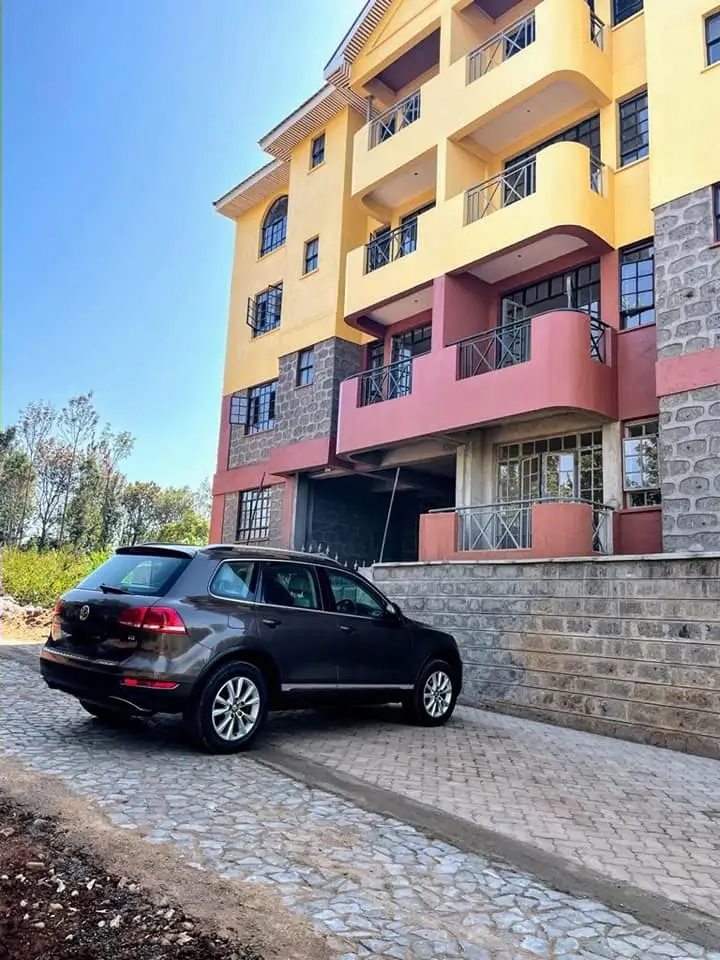 Multi-story residential building with paved parking bay entrance