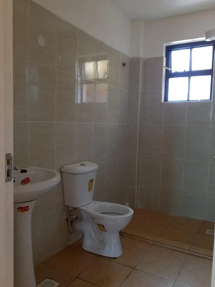 Spacious bathroom with toilet, sink, and shower enclosure