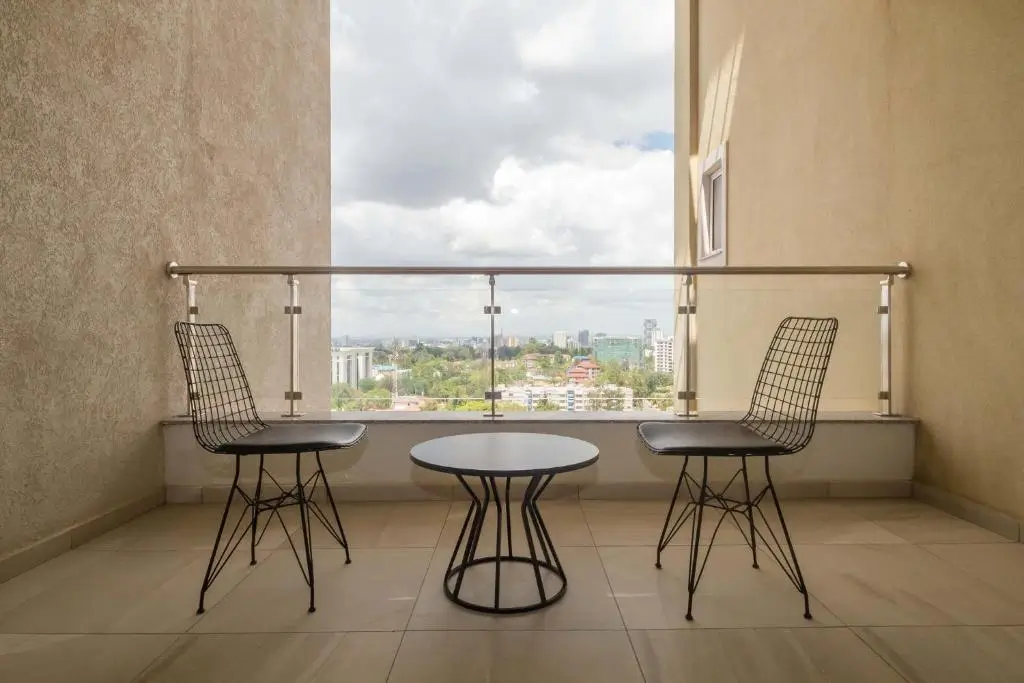 Modern balcony with city views, glass railing, two chairs