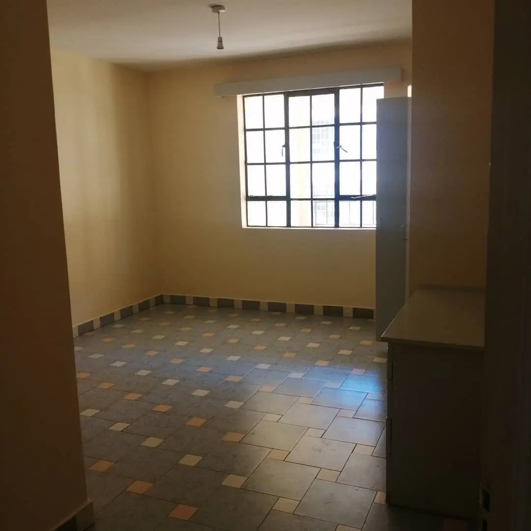 Spacious living room with natural light and tiled flooring