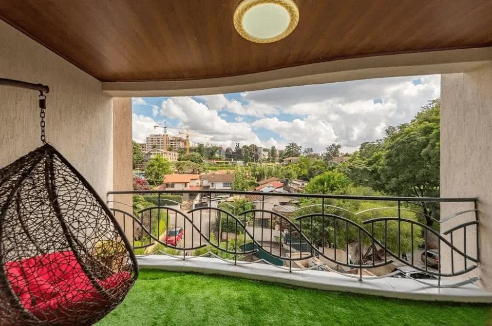Spacious balcony with hanging chair, artificial turf, city views