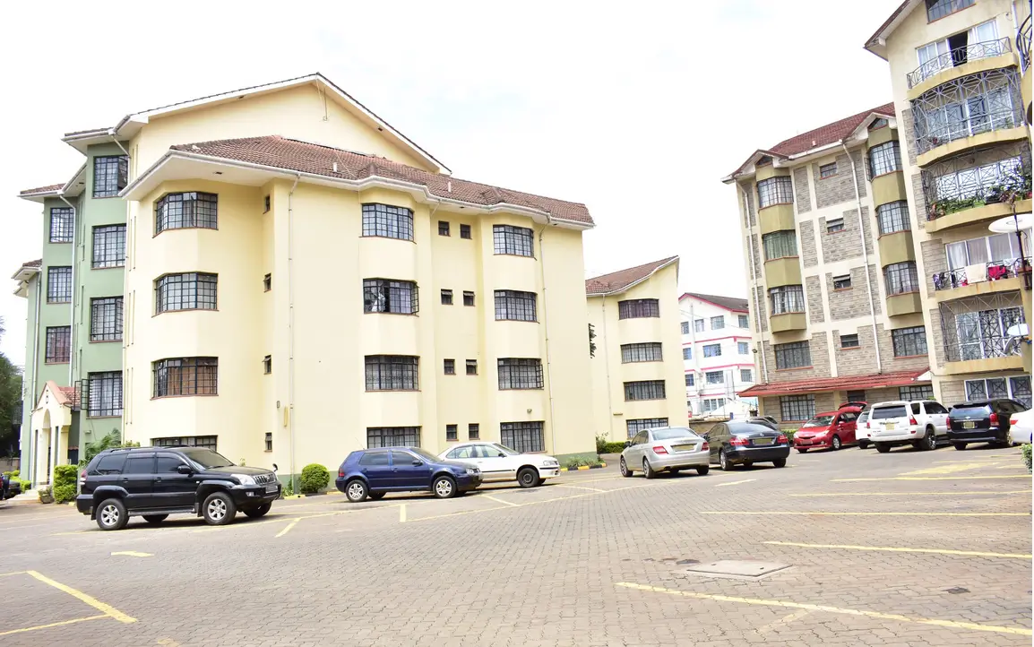 Multi-story residential buildings with paved parking compound