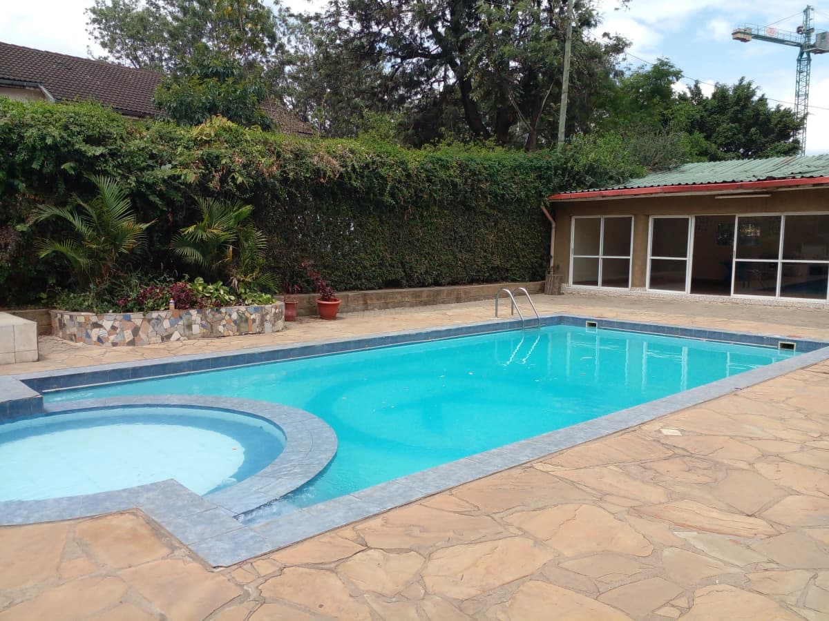 Large rectangular swimming pool with jacuzzi and poolside deck