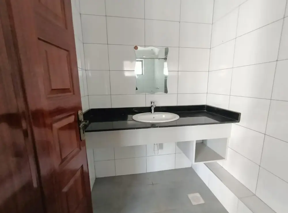Bathroom with black countertop sink and white tiled walls