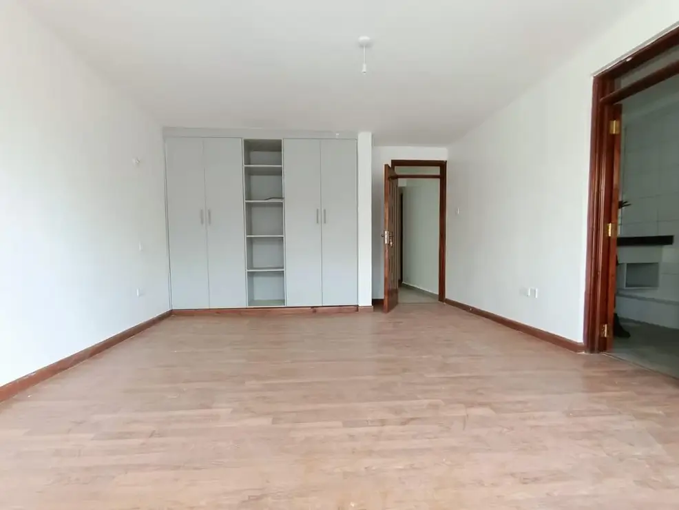 Spacious bedroom with built-in wardrobes and wooden flooring