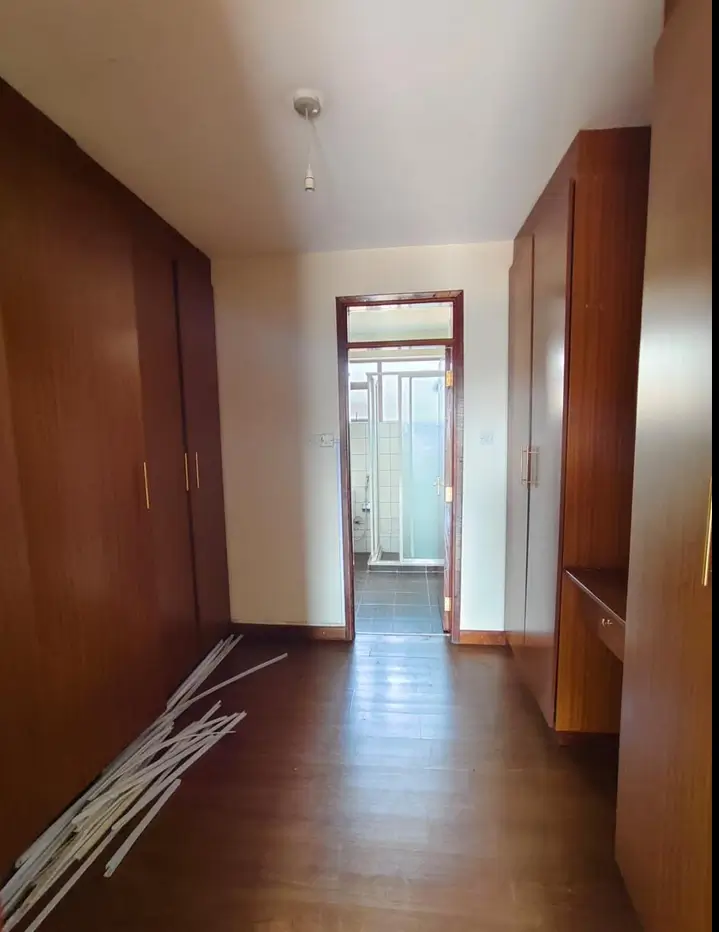 Hallway with wooden wardrobes and glass door ahead