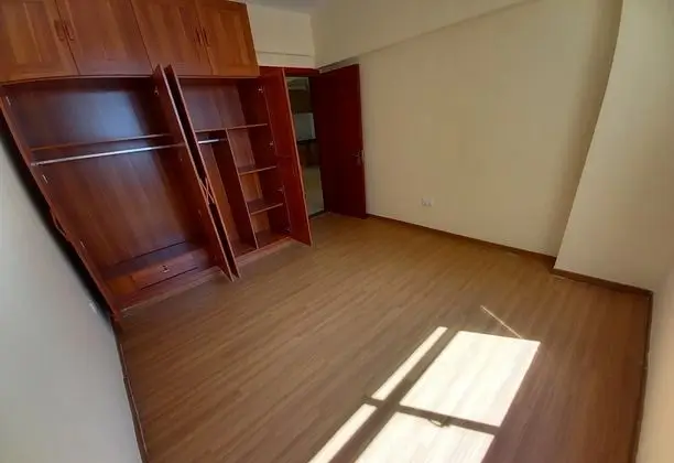 Spacious bedroom with wooden wardrobe and natural light