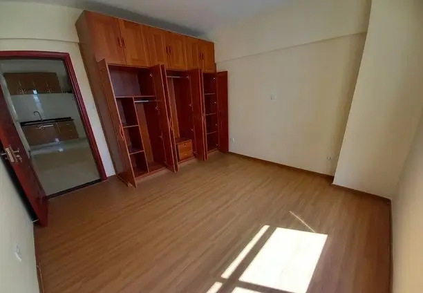 Spacious bedroom with wooden wardrobe and natural light