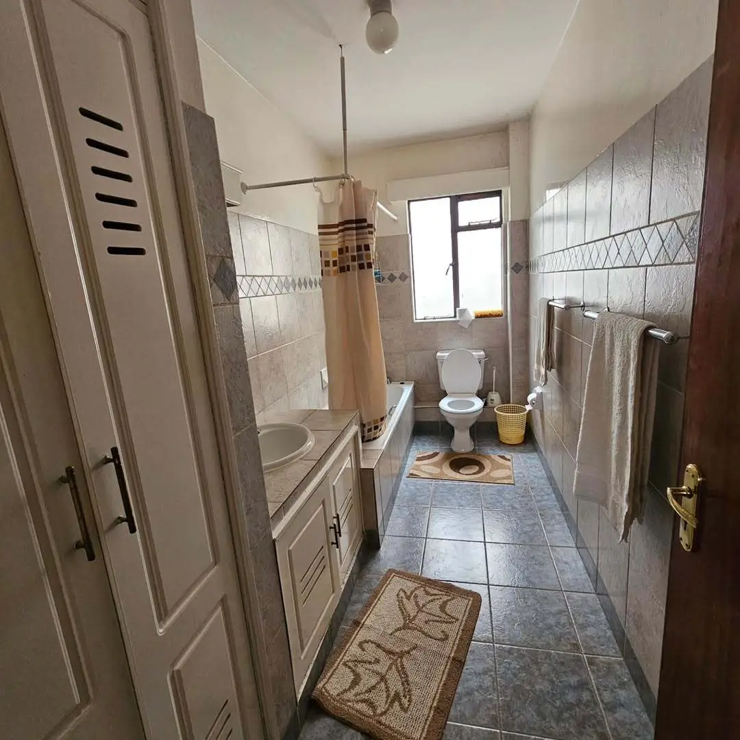 Long narrow bathroom with shower enclosure and dual vanity