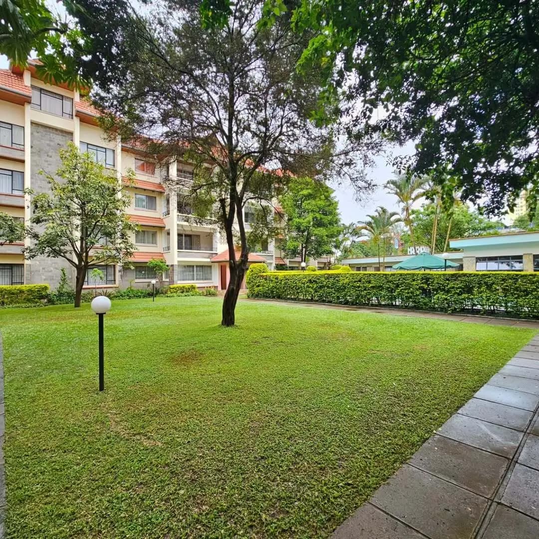 Manicured compound lawn with mature trees and landscaping