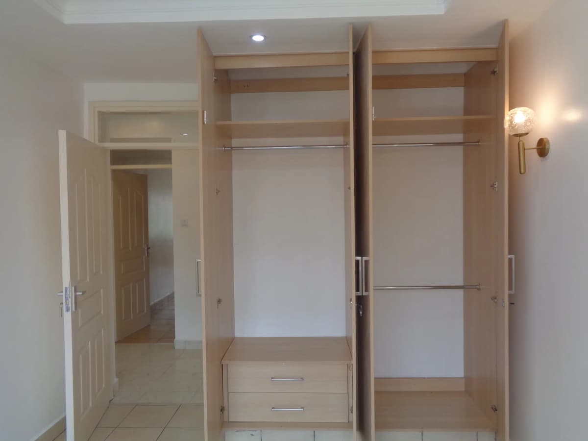 Bedroom with built-in wooden wardrobes and shelving