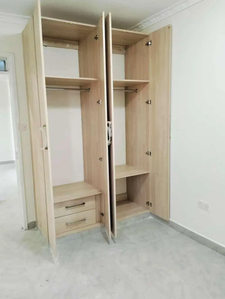 Built-in wooden wardrobe with double doors and shelving