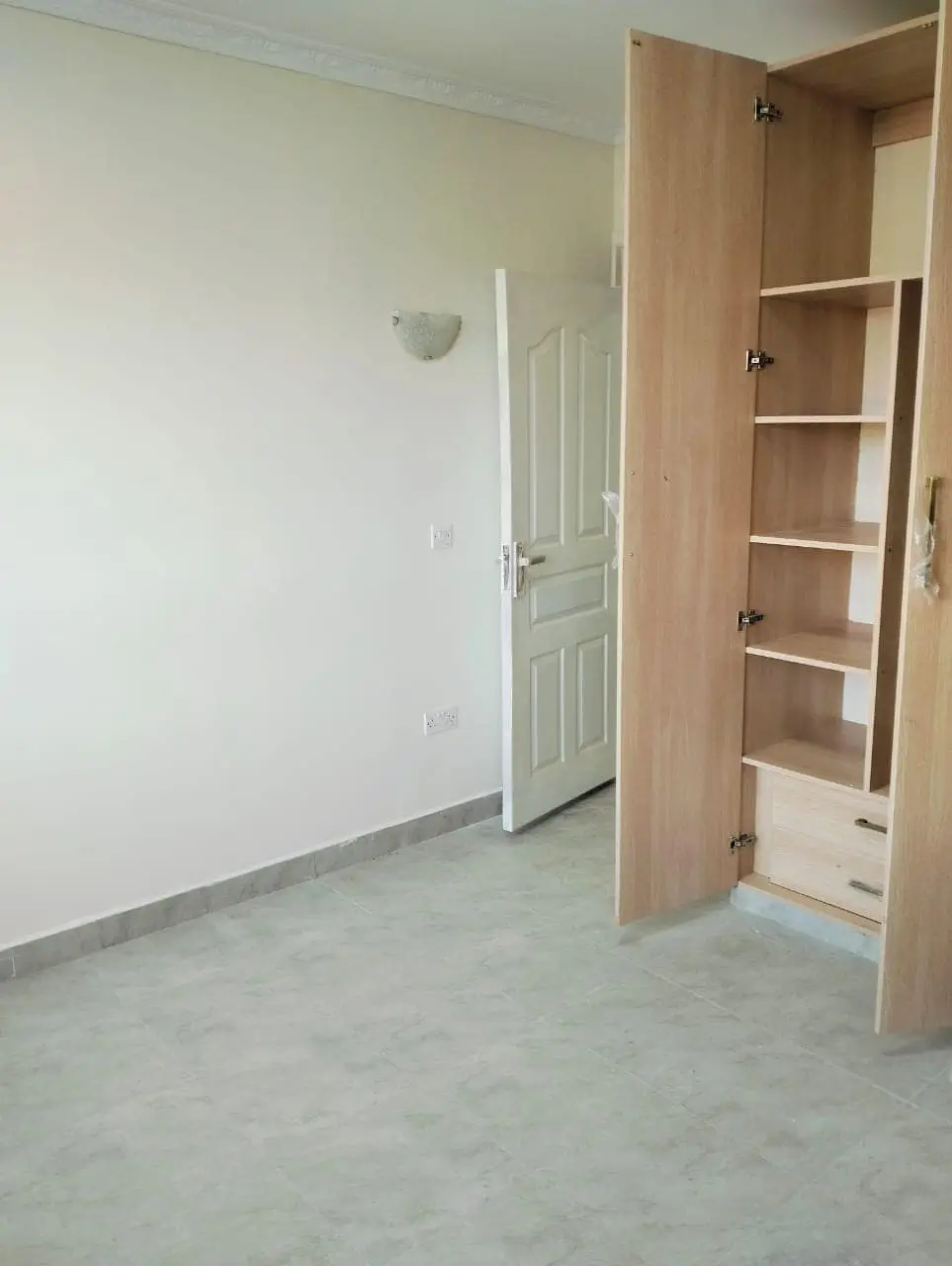 Unfurnished bedroom with built-in wooden wardrobe storage