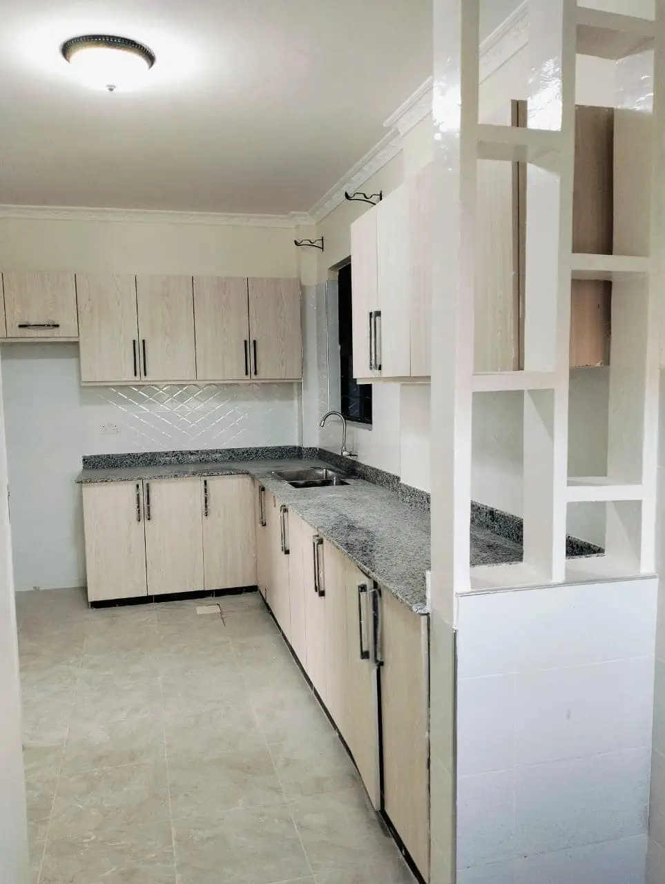 Modern kitchen with cream cabinets and grey granite countertops