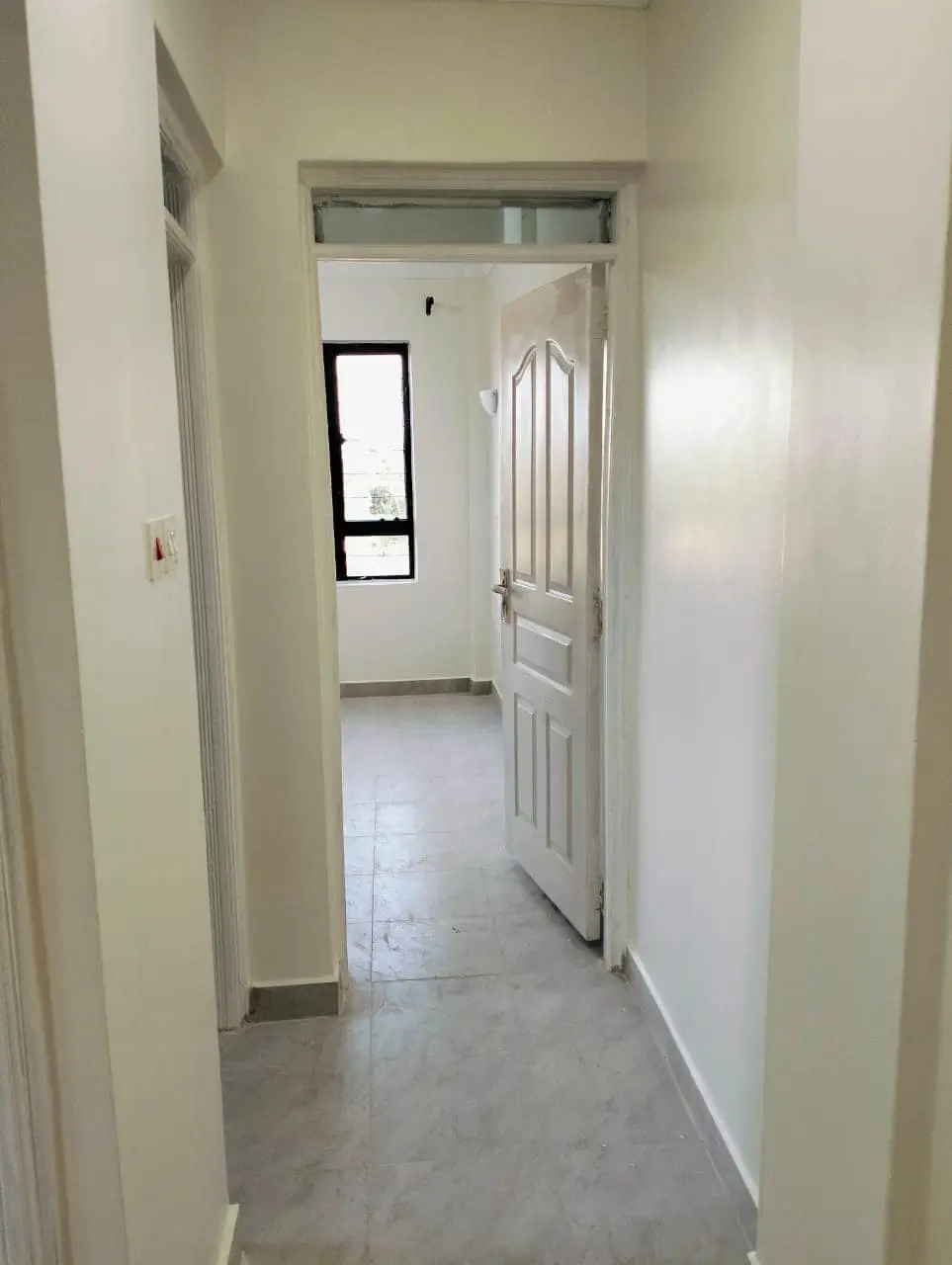 Bright hallway with white walls and polished concrete floor