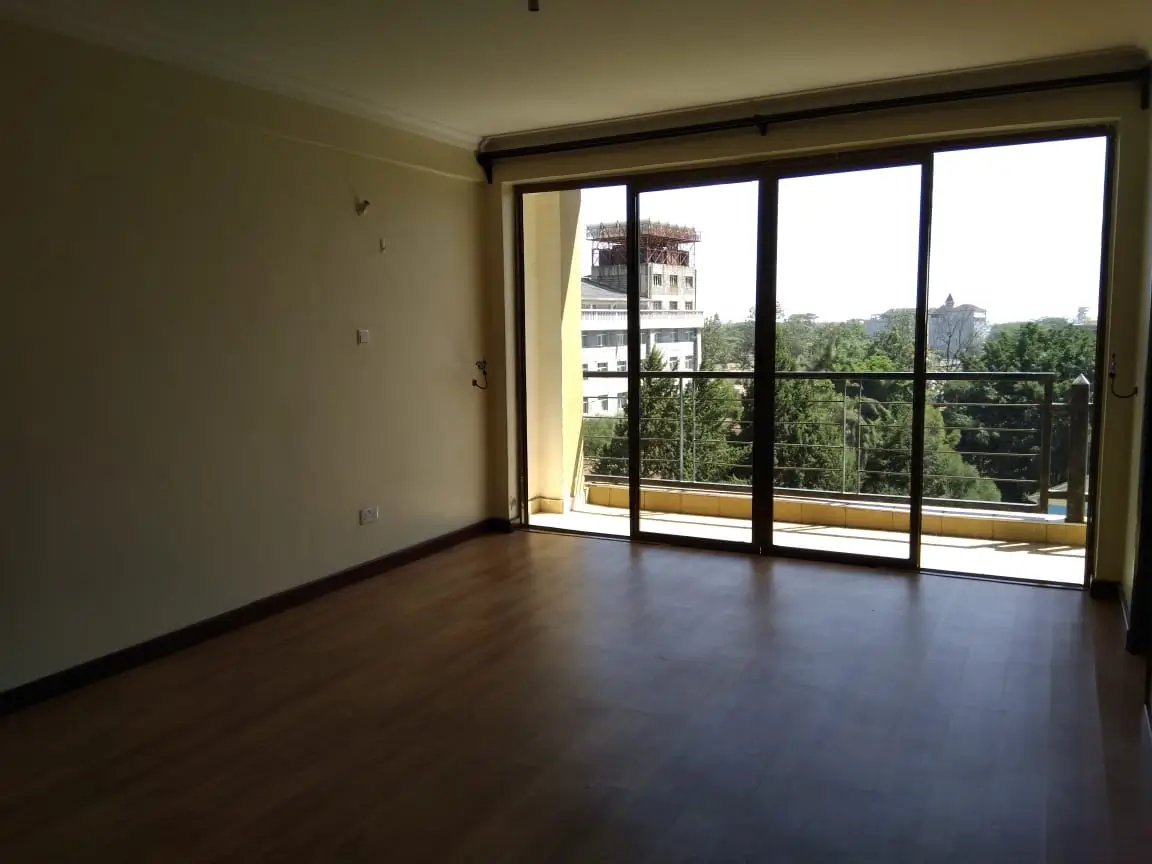 Spacious room with panoramic views of green landscape and buildings