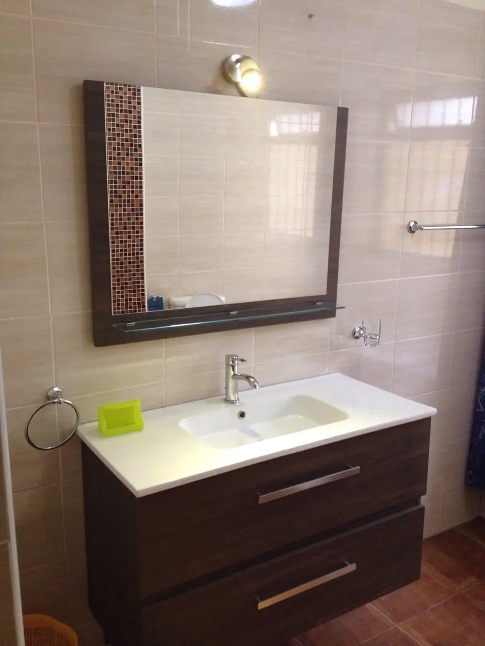 Modern bathroom with dark vanity, white sink, framed mirror