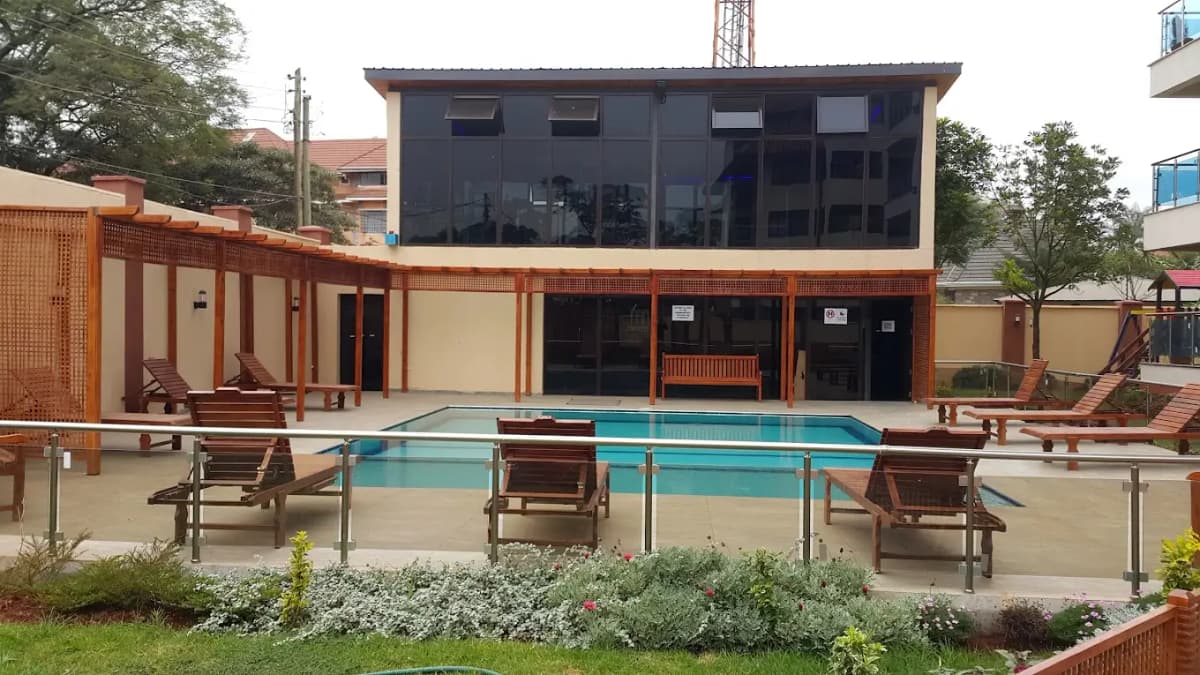 Turquoise swimming pool with loungers and landscaped grounds