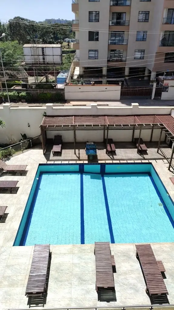 Olympic-length swimming pool with loungers and covered pavilion