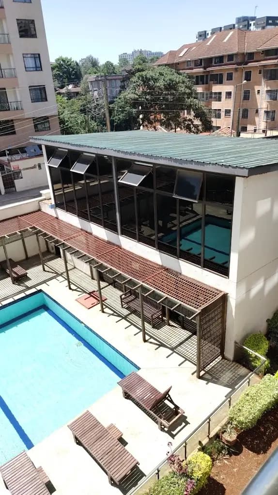 Resort-style swimming pool with loungers and glass pavilion