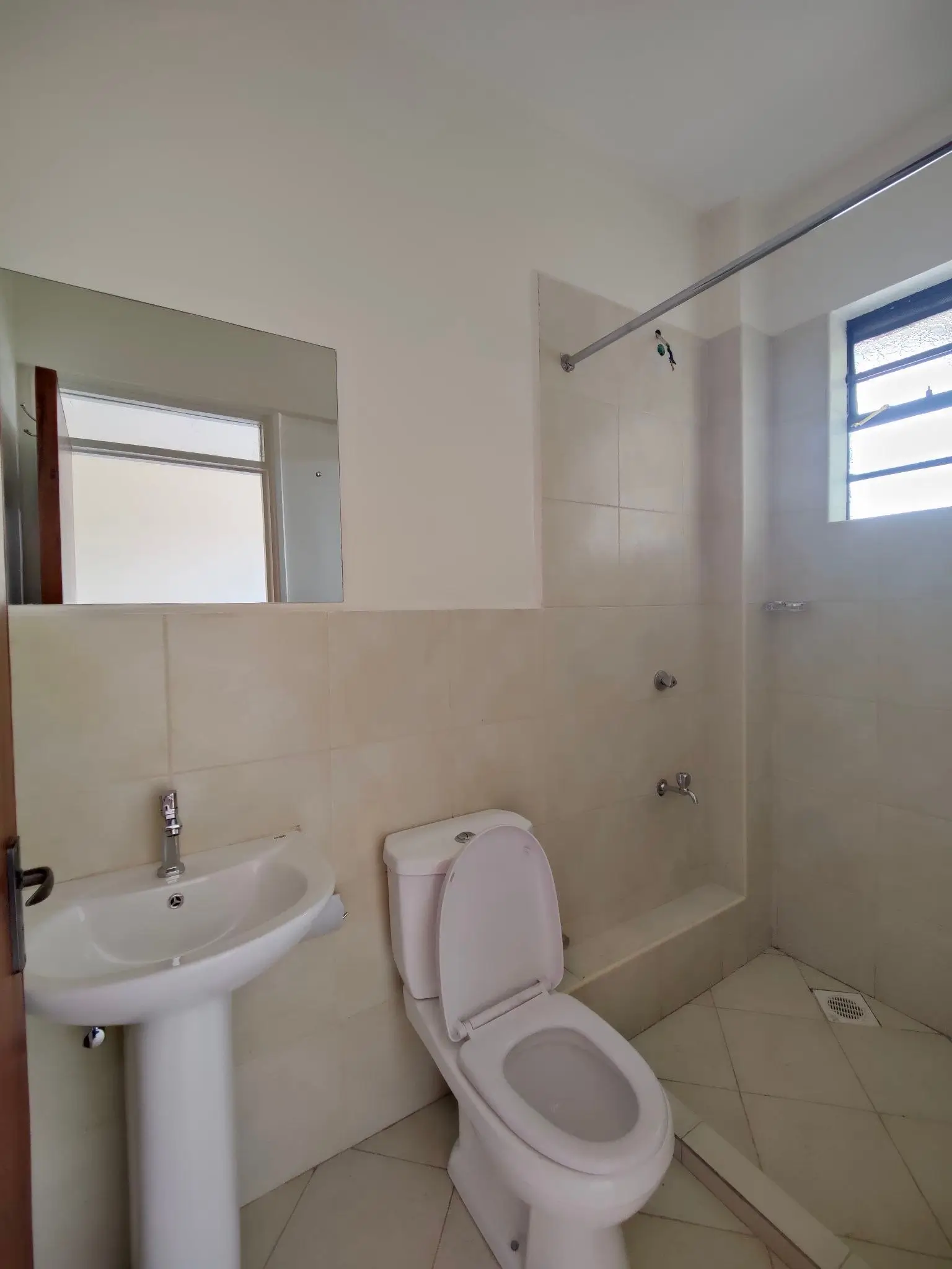 Clean bathroom with pedestal sink, toilet, and walk-in shower