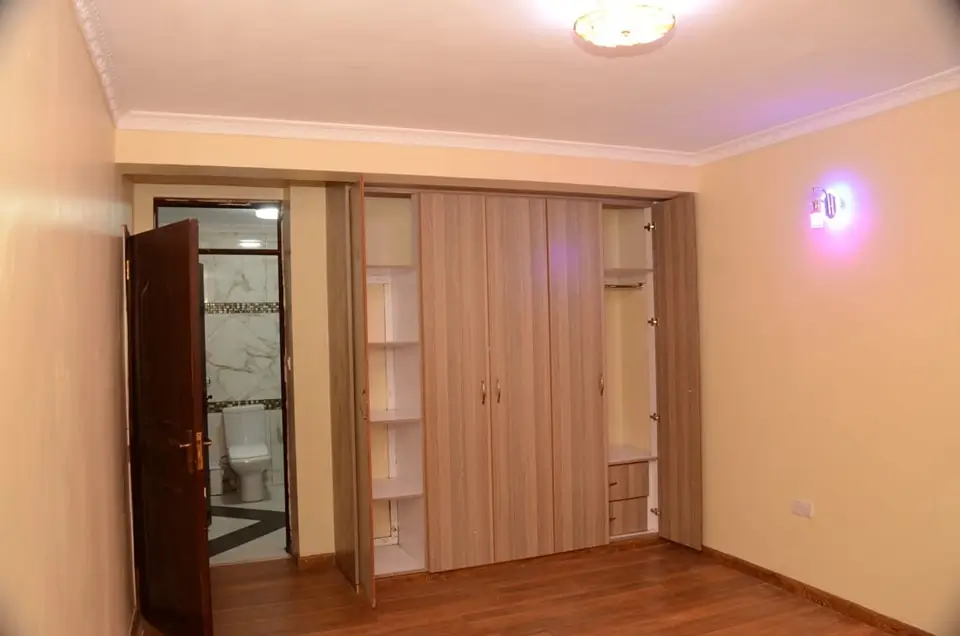 Spacious bedroom with wooden wardrobe and ambient lighting