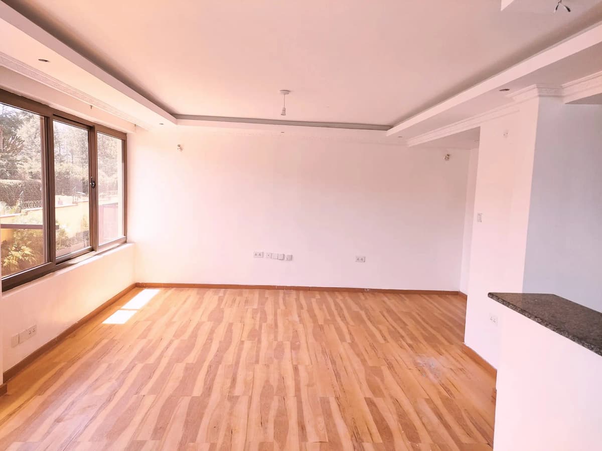 Spacious living room with wooden flooring and natural light