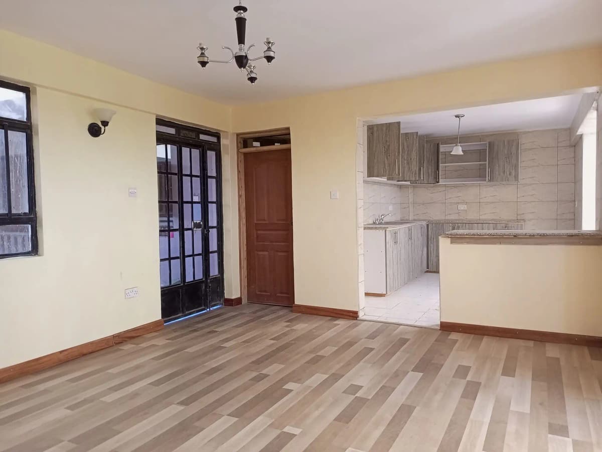 Open-plan living room with kitchen visible through counter partition