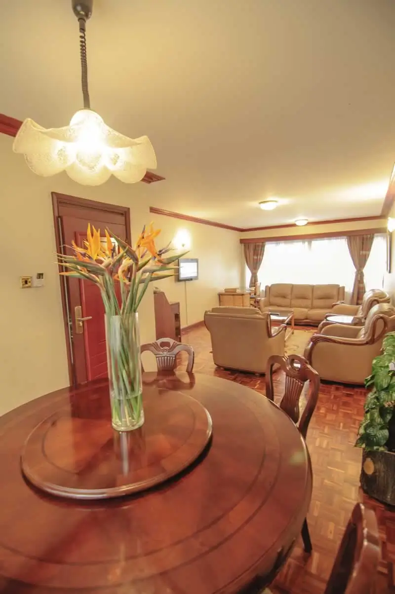 Elegant lobby with round table, flowers, and lounge seating beyond