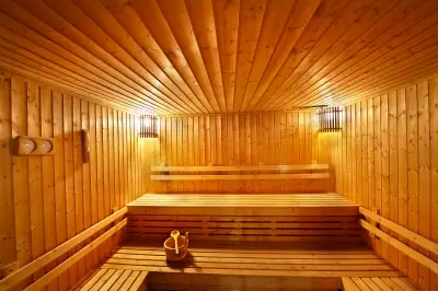 Traditional wooden sauna room with tiered benches and lighting