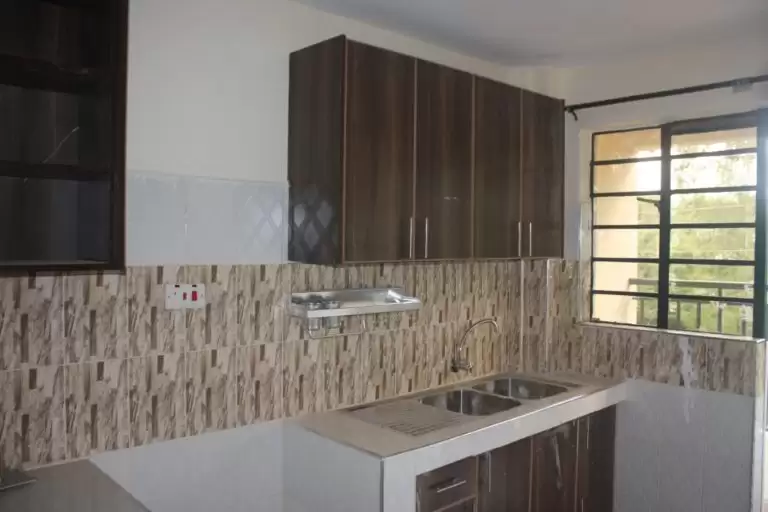 Modern kitchen with dark cabinetry and geometric tile backsplash