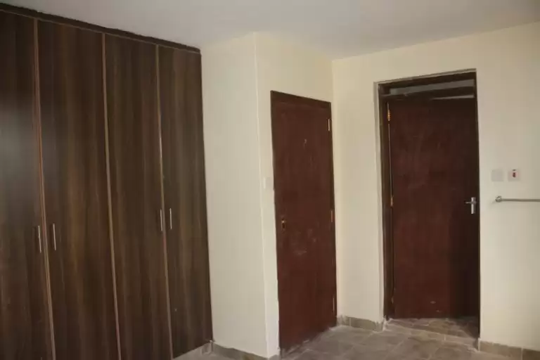 Unfurnished bedroom with built-in wardrobes and neutral walls
