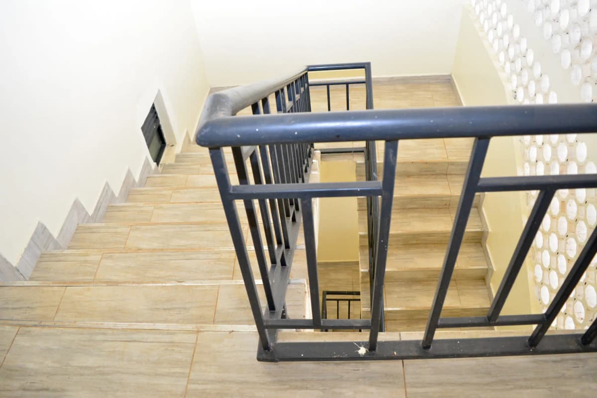 Interior staircase with metal railing and wooden steps
