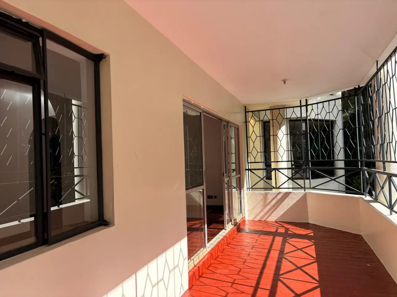 Spacious covered balcony with terracotta tiles and black railings