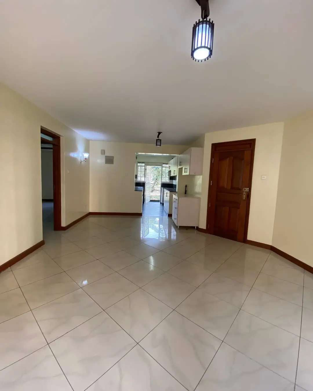 Spacious tiled corridor with multiple doorways and natural light