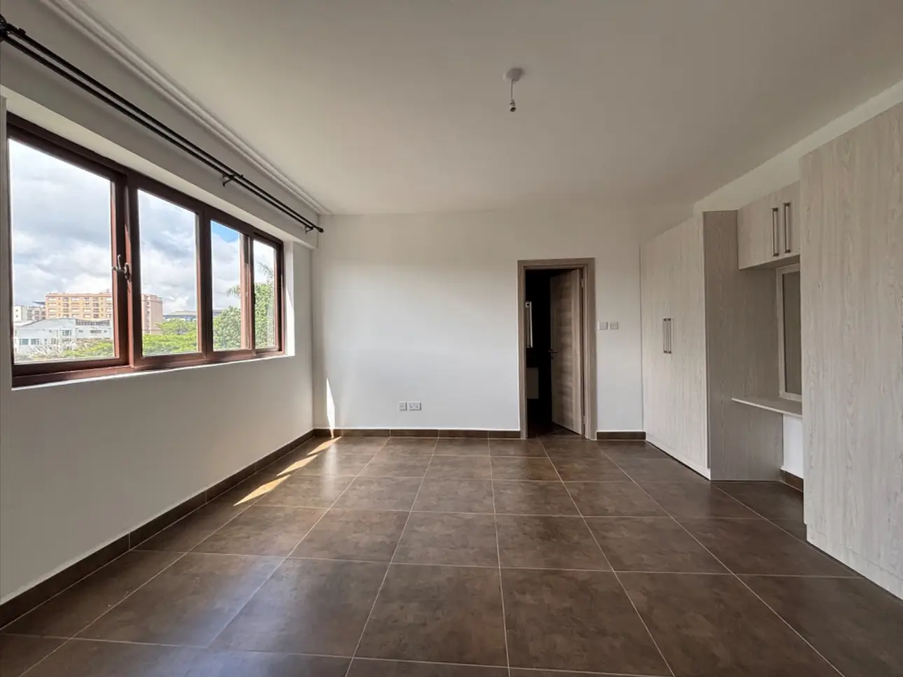 Open-plan living space with dark tile flooring and city views