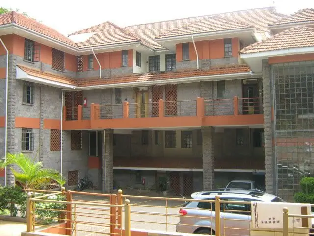 Modern multi-story residential building with orange and gray facade