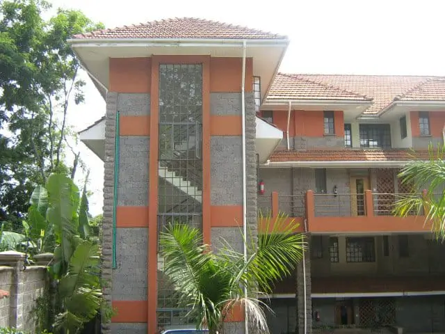 Modern multi-story residential building with orange and gray facade