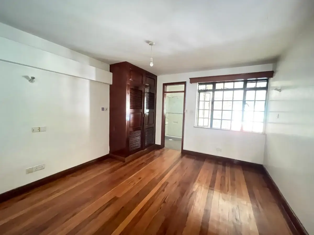 Spacious bedroom with wooden floors and built-in wardrobe