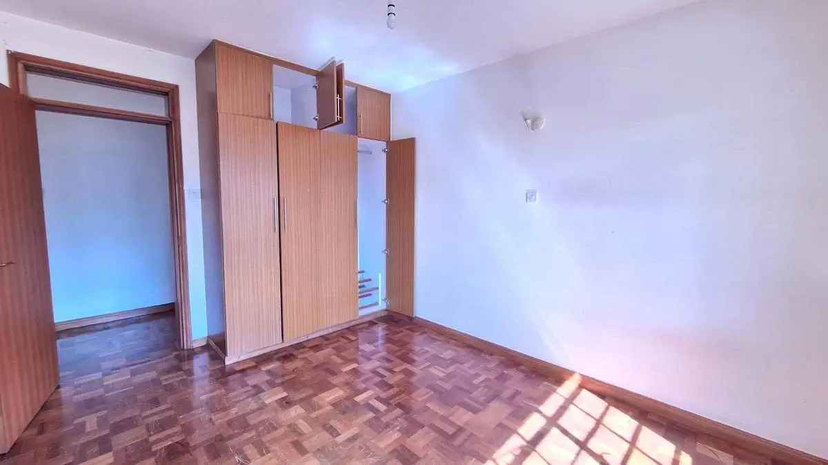 Spacious bedroom with wooden wardrobe and parquet flooring