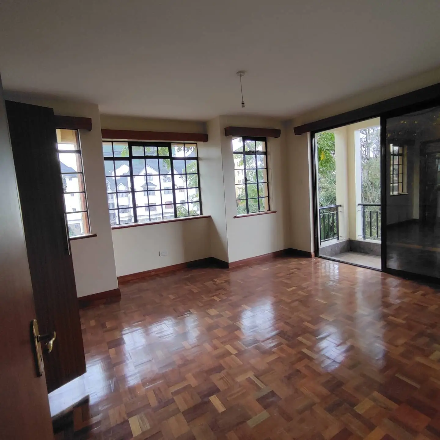 Spacious living room with herringbone flooring and glass doors