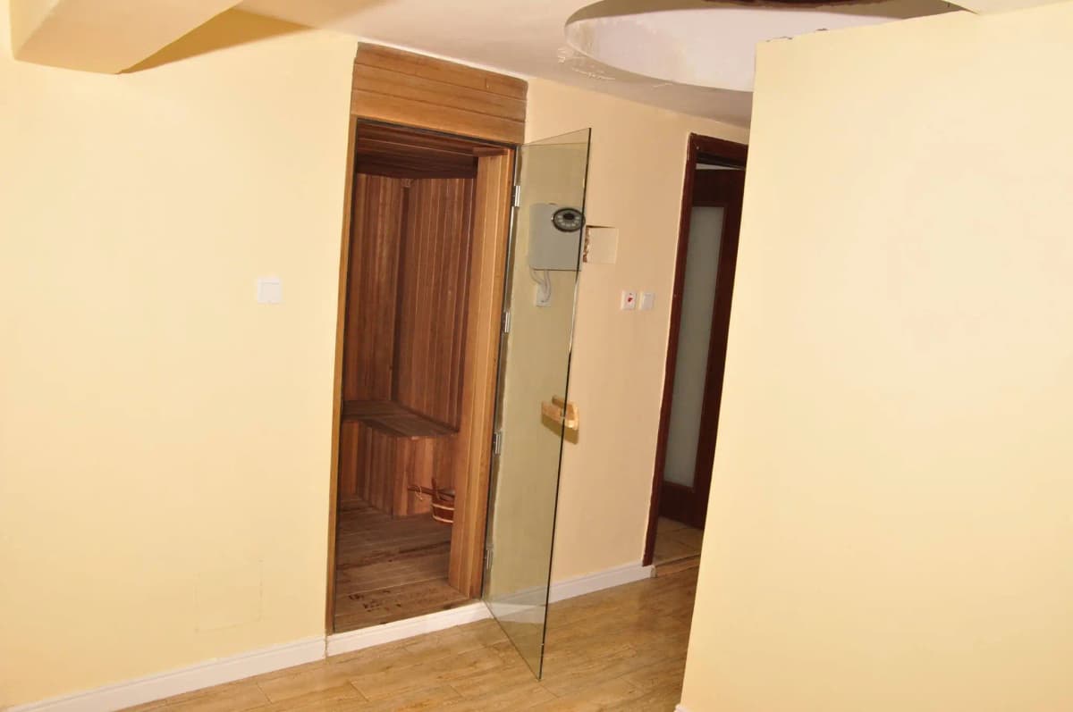 Building corridor with wooden door and glass shower enclosure