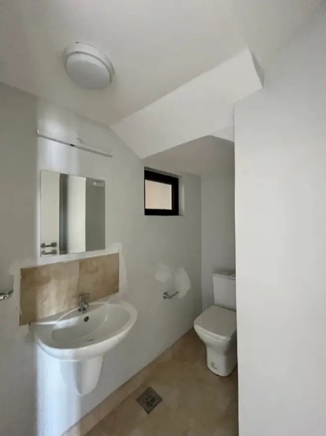 Compact white bathroom with pedestal sink and toilet