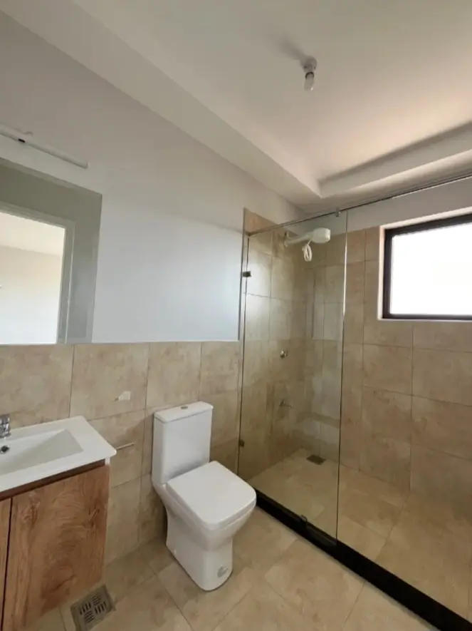 Clean en-suite with glass shower, toilet and vanity