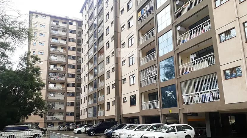 Multi-story residential building facade with ground-level parking bays