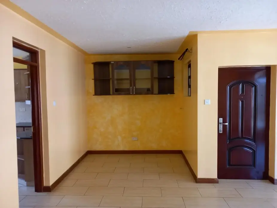 Open-plan living area with kitchen pass-through and tile flooring