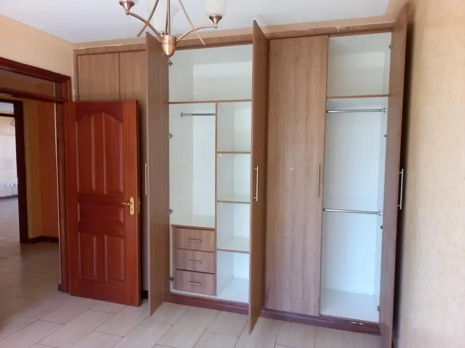 Spacious bedroom with large mirrored wardrobe and pendant lighting