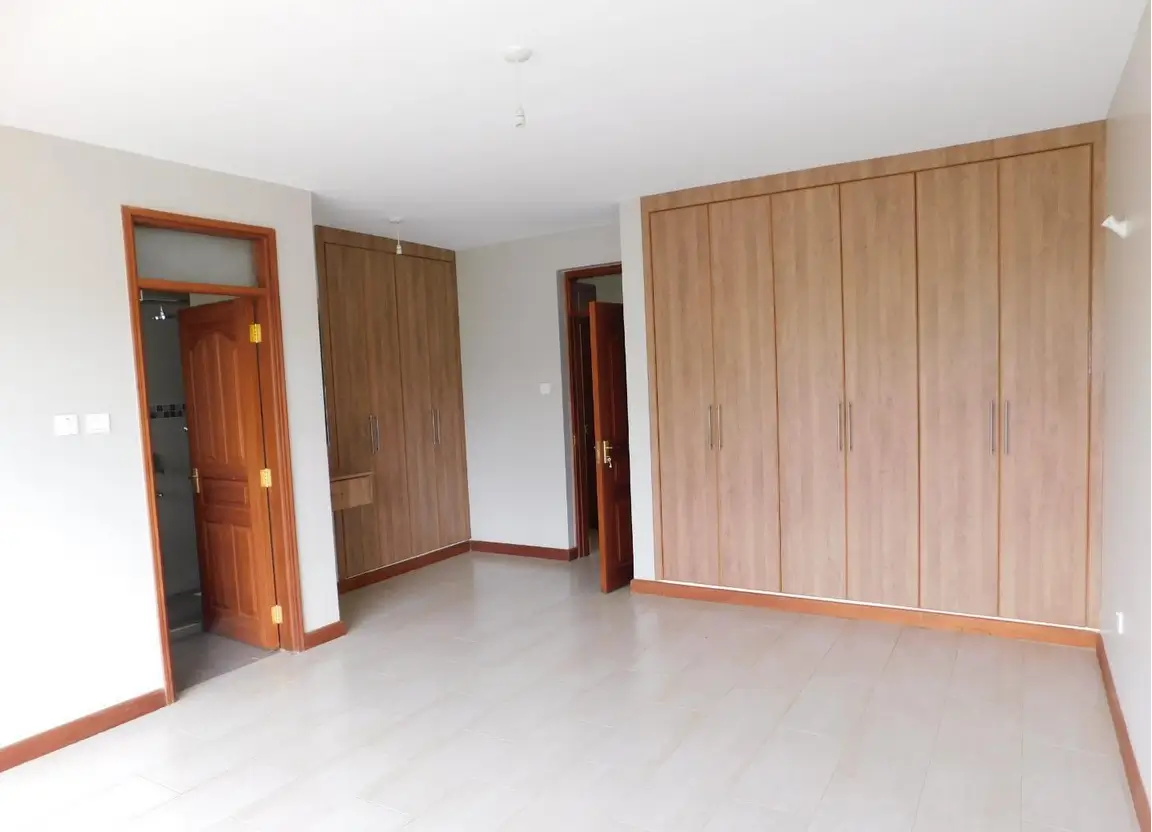 Spacious bedroom with wooden wardrobe and multiple doors